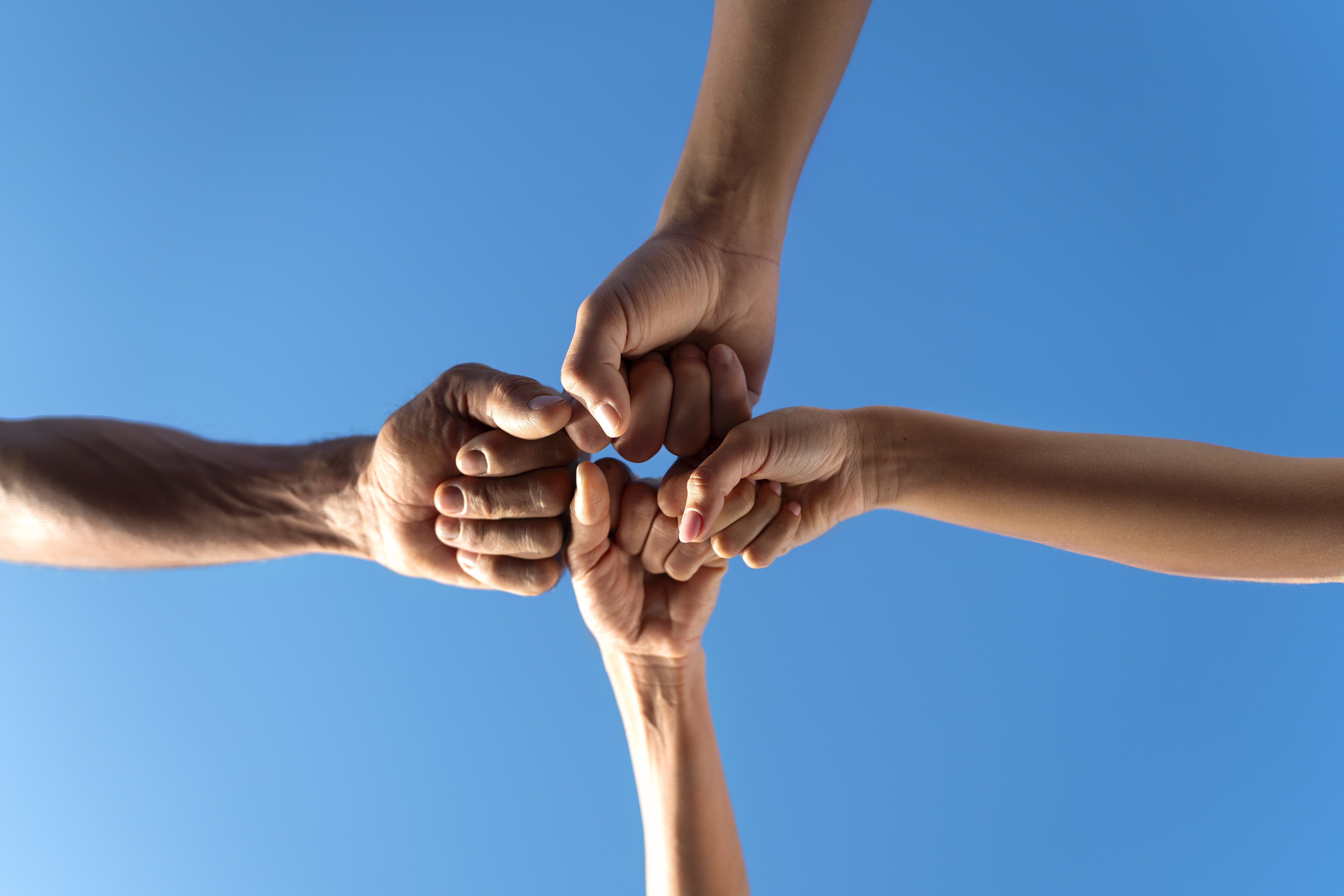 group-people-putting-their-hands-together-while-exercising-outdoors